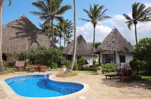 un complexe avec une piscine et des palmiers dans l'établissement Sultan Sands Island Resort, à Kiwengwa
