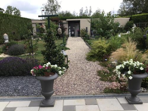 a garden with two vases with flowers in it at B&B Marianne in Binche