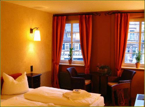 a hotel room with a bed and two windows at Hotel Villa Boddin in Heppenheim an der Bergstrasse