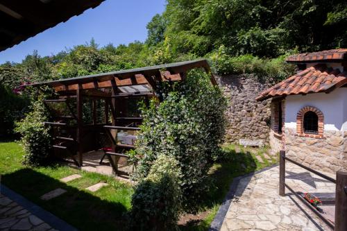 a garden with a pavilion and a stone wall at Casa Ortiz in Soto de Cangas