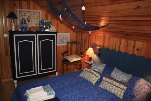 a bedroom with a blue bed in a cabin at leschambresdanne in Chameyrat