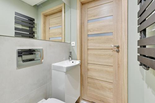 a bathroom with a toilet and a sink at Victus Apartamenty, Apartamenty Panamera in Sopot