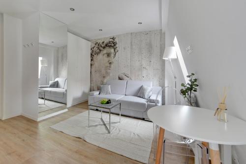 a white living room with a couch and a table at Victus Apartamenty, Apartamenty Panamera in Sopot