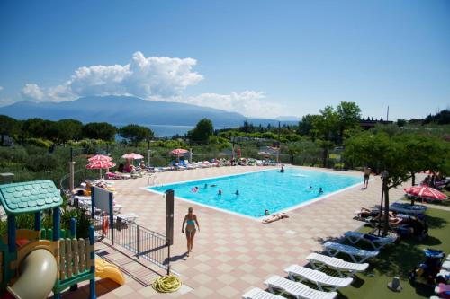 una piscina en un complejo con gente dentro en Casa mobile - Eden Camping Village, en San Felice del Benaco