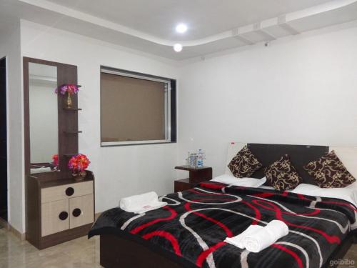 um quarto com uma cama e um espelho em Indira Villa - 3BHK Getaway near WaterFalls em Mahabaleshwar