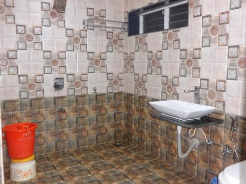 uma casa de banho com um lavatório e uma parede em azulejo em Indira Villa - 3BHK Getaway near WaterFalls em Mahabaleshwar