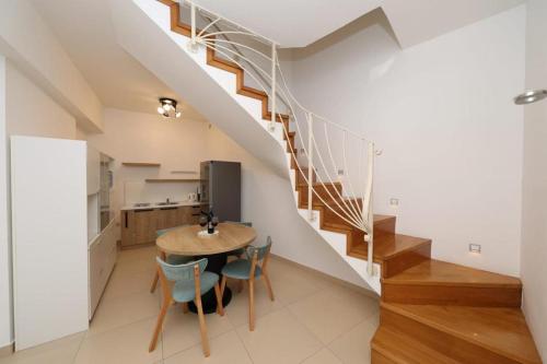 a dining room with a table and a staircase at Apartment Anastazija in Omiš