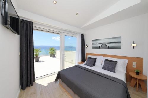 a bedroom with a bed and a large window at Apartment Anastazija in Omiš