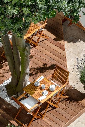 - une vue sur une table et des chaises sur une terrasse en bois dans l'établissement Maison des Ambassadeurs, à La Rochelle