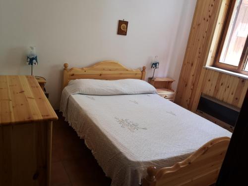 - une chambre avec un lit et une table en bois dans l'établissement Camigliatello Mom&Son, à Camigliatello Silano