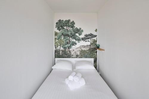 - un lit blanc avec 2 serviettes blanches dans l'établissement L'Opalin by Cocoonr - en plein cœur de Dinard, à Dinard