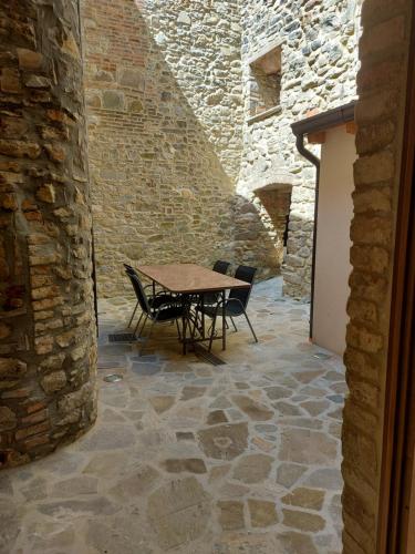 un patio con tavolo e sedie in un edificio in pietra di LA MONTADARIA a Zavattarello