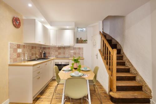 une cuisine avec une table et des chaises ainsi qu'un escalier dans l'établissement La Belle à Colombage, à Dinan
