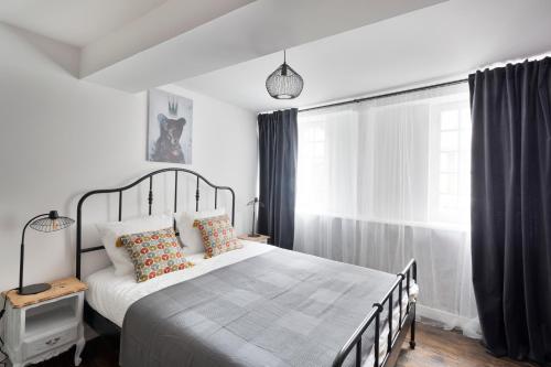 a bedroom with a large bed and a window at La Belle à Colombage in Dinan