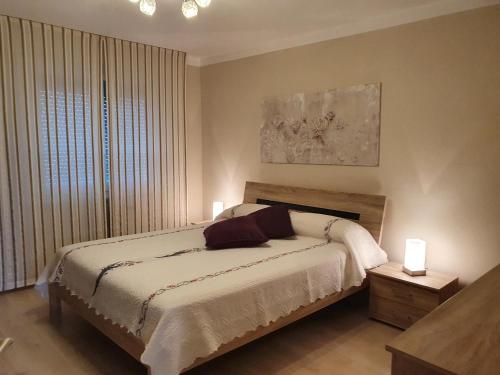 Appartement Cime l'Est في سانت موريس: غرفة نوم بها سرير مع مصباحين