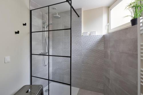 La salle de bains est pourvue d'une douche avec des portes en verre. dans l'établissement LE BROOKLYN - Inspiration US à deux pas des quais, à Rennes
