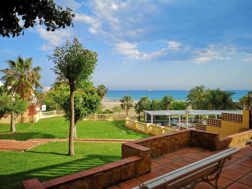 park z ławką i widokiem na plażę w obiekcie Beach Apartment - Benalmadena Costa w mieście Benalmádena
