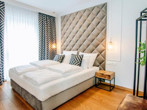 - une chambre avec un grand lit et une grande tête de lit dans l'établissement EL Apartments - Orion, à Poznań