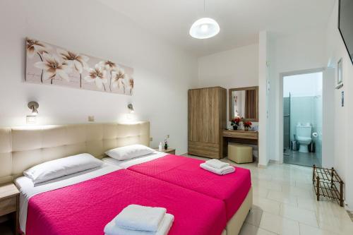 a bedroom with a large bed with a red blanket at Villa Maroula in Afantou