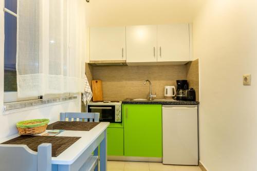 a kitchen with green cabinets and a green refrigerator at Villa Maroula in Afantou