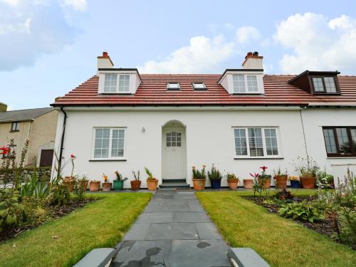 a white house with a red roof at One Dolfor in Pwllheli