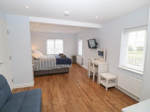 a bedroom with a bed and a desk at One Dolfor in Pwllheli