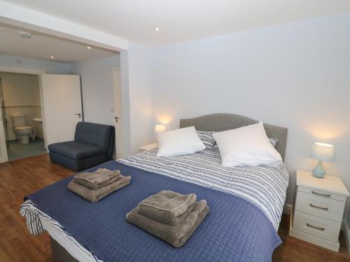 a bedroom with a bed with towels on it at One Dolfor in Pwllheli