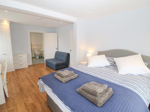a bedroom with a bed with towels on it at One Dolfor in Pwllheli