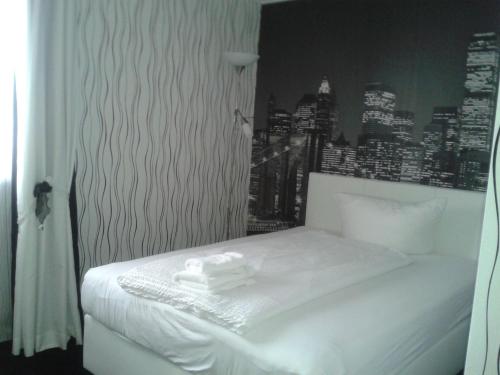 a bedroom with a white bed with a city skyline at Hotel Ackermann in Riedstadt