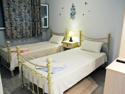 two twin beds in a room with blue walls at Studios Dimitra in Spartià
