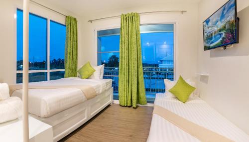 ナコーンシータンマラートにあるChada@Nakhonのベッドルーム1室(ベッド2台、大きな窓付)