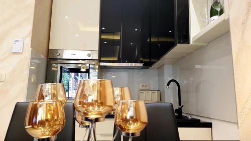 a row of wine glasses sitting on a table in a kitchen at Lux apartman Zlatibor S14 - vila Peković in Zlatibor