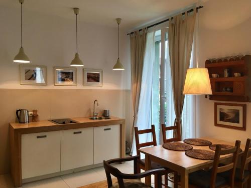 a kitchen and dining room with a table and chairs at Studio 4U Zakopane APARTZAKOP in Zakopane