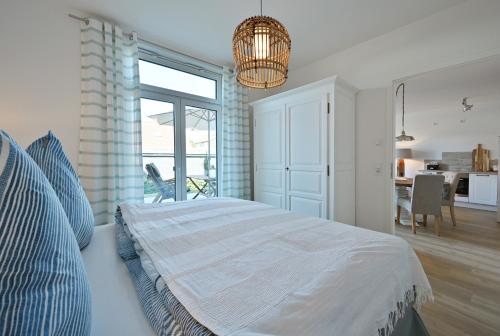 a bedroom with a bed and a dining room at Ferienwohnung TreibGood in Glowe