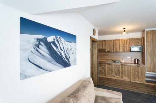 een keuken met een foto van een met sneeuw bedekte berg bij Apartmany JA&MA in Liptovský Mikuláš