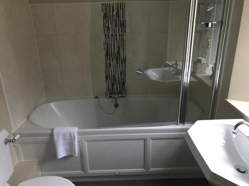un baño con bañera y lavabo en North Lodge, en Invergarry
