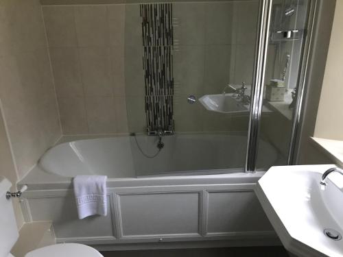 a bathroom with a bath tub and a sink at North Lodge in Invergarry