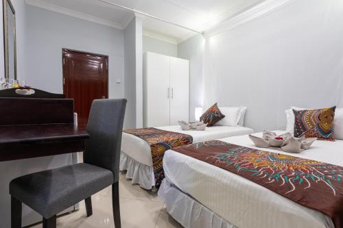 a bedroom with two beds and a desk and a chair at Nzubo Experience in Livingstone