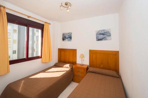 1 Schlafzimmer mit 2 Betten und einem Fenster in der Unterkunft Topacio 4 Calpe Beach in Calpe