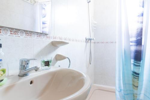 a white bathroom with a sink and a mirror at Estudio en el Centro de Denia in Denia