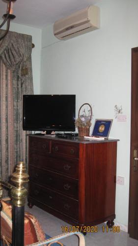 uma televisão numa cómoda numa sala de estar em Merzuq House em Birzebbuga