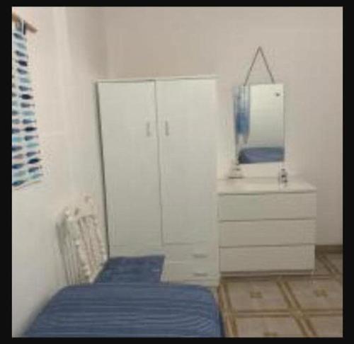- une chambre avec un lit bleu et un miroir dans l'établissement Casa Vacanza Rosanna, à Torre Lapillo