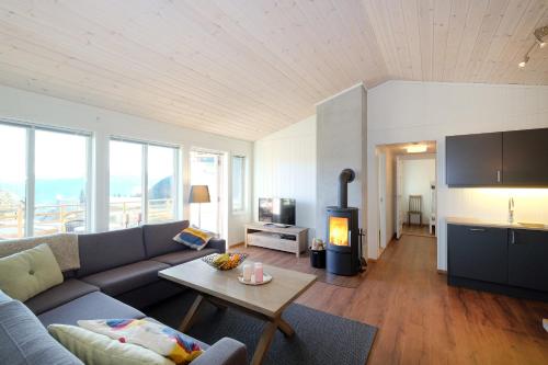 ein Wohnzimmer mit einem Sofa und einem Holzofen in der Unterkunft Voss Resort Bavallstunet in Skulestadmo