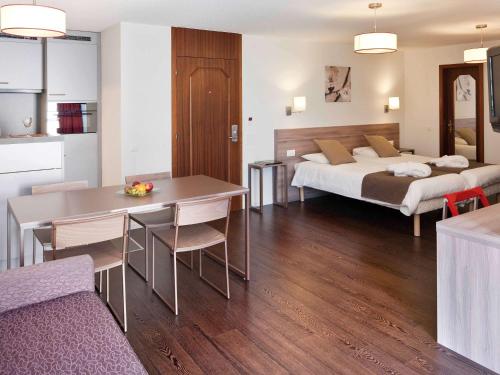 a hotel room with two beds and a table and chairs at Mercure Biel in Biel