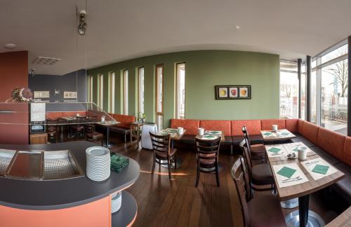 a restaurant with tables and chairs and a couch at Businesshotel Valerian in Hohenems