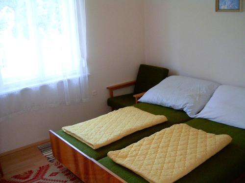 ザラカロシュにあるHársfa Vendégházのベッドルーム1室(ベッド2台、椅子、窓付)