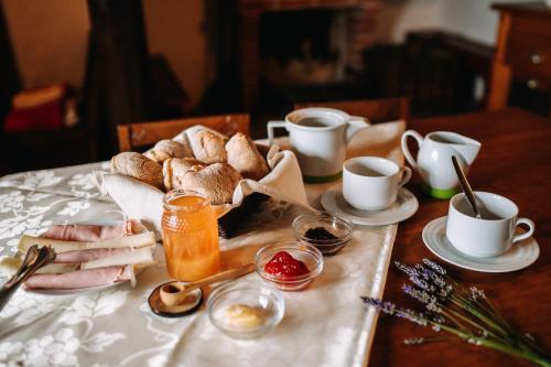 a table with a tray of bread and cups of coffee at Casas de Pedra - Quinta da Escola in Alvados