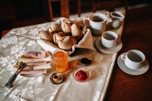 a table with a tray of bread and cups of coffee at Casas de Pedra - Quinta da Escola in Alvados
