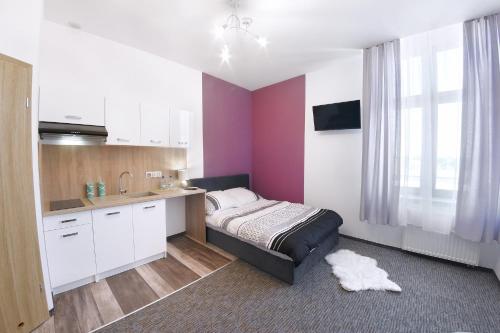 a bedroom with a bed and a kitchen with a sink at Willa Zator in Oświęcim