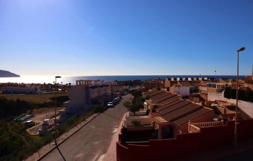 a city street with buildings and the ocean in the background at El Alamillo seaview Penthouse in Mazarrón